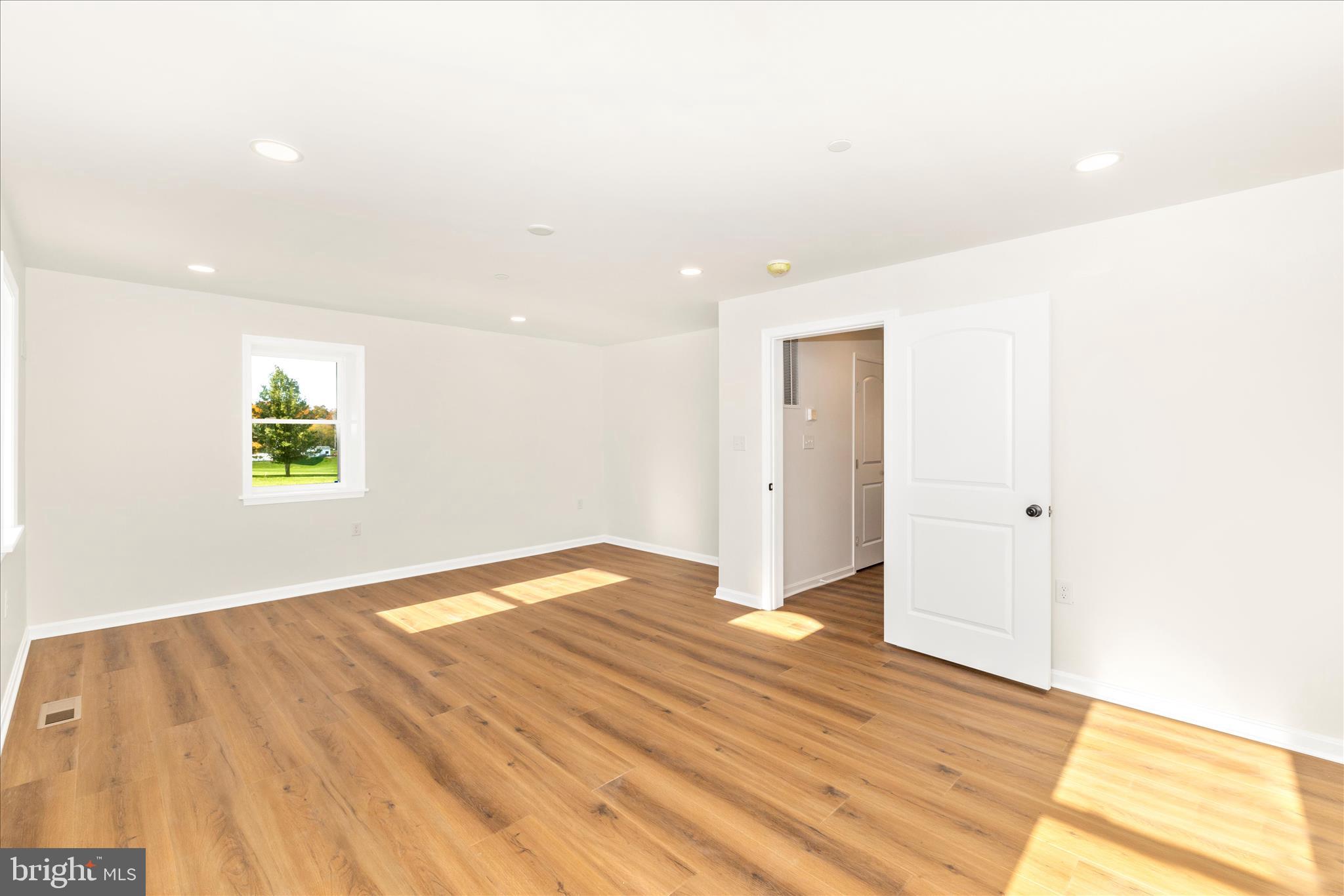 10910 Liberty Road Frederick, MD 21701 - Photo 21 of 51 a view of an empty room with wooden floor and a window