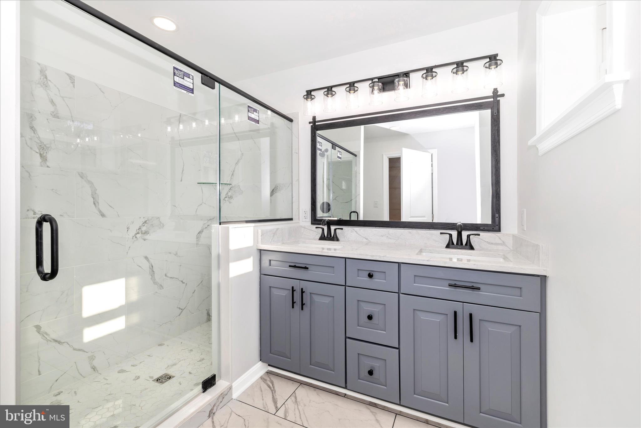 10910 Liberty Road Frederick, MD 21701 - Photo 25 of 51 a bathroom with a double vanity sink mirror and shower