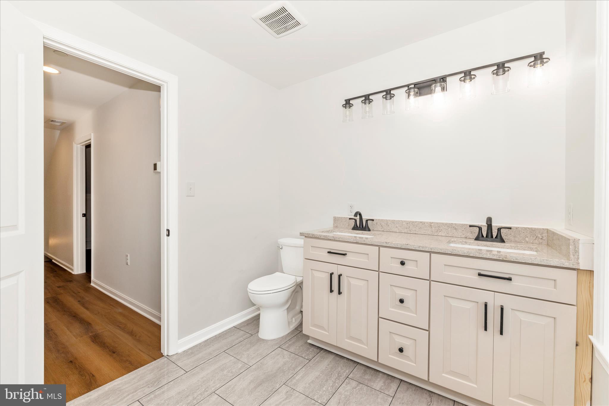 10910 Liberty Road Frederick, MD 21701 - Photo 36 of 51 a bathroom with a granite countertop sink mirror vanity and toilet