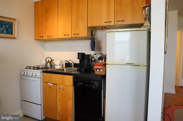 a kitchen with appliances a sink and cabinets