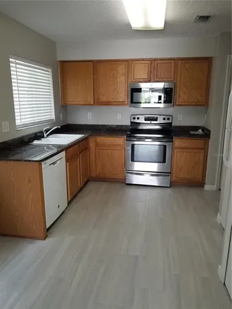a kitchen with stainless steel appliances a stove a sink and a microwave