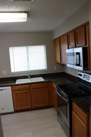 a kitchen with granite countertop a stove and a sink