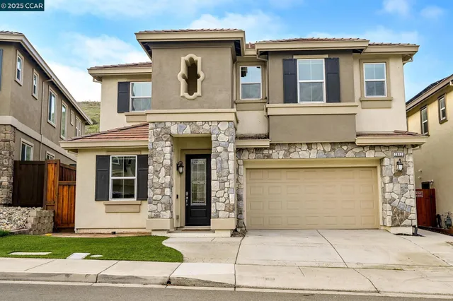 a front view of a house with a garden and garage