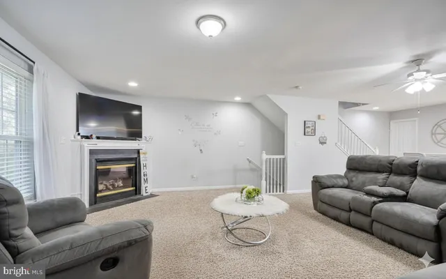 a living room with furniture kitchen view and a fireplace