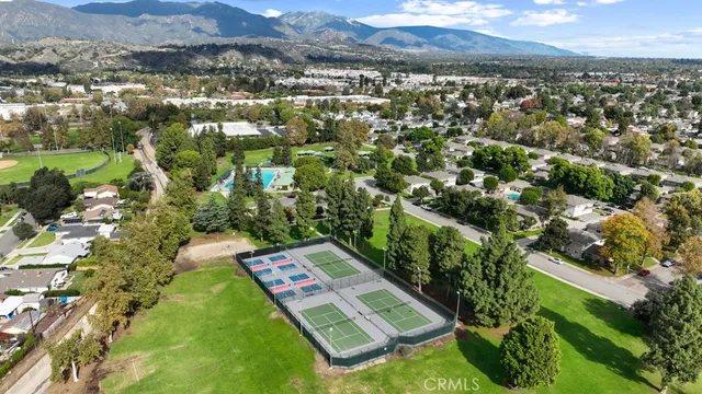 an aerial view of residential houses with outdoor space and trees
