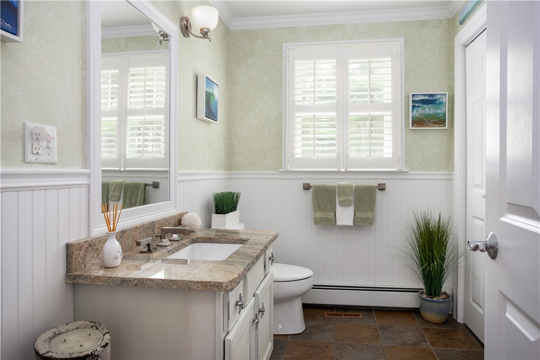 9 Cedar Meadows Road Charlestown, RI 02813 - Photo 18 of 39 First floor powder room has granite, wainscoting, tile floor & a large storage closet.