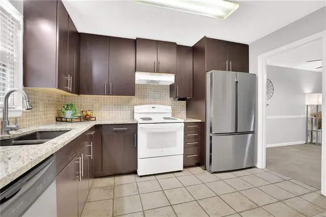 a kitchen with a refrigerator sink and cabinets
