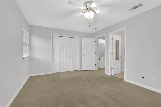 a view of an empty room with a chandelier fan