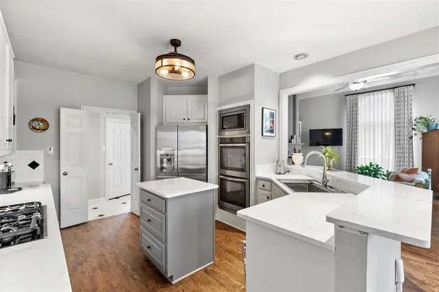 a living room with stainless steel appliances kitchen island granite countertop furniture a rug and a window