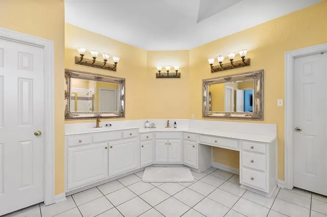 a spacious bathroom with a granite countertop sink and a mirror