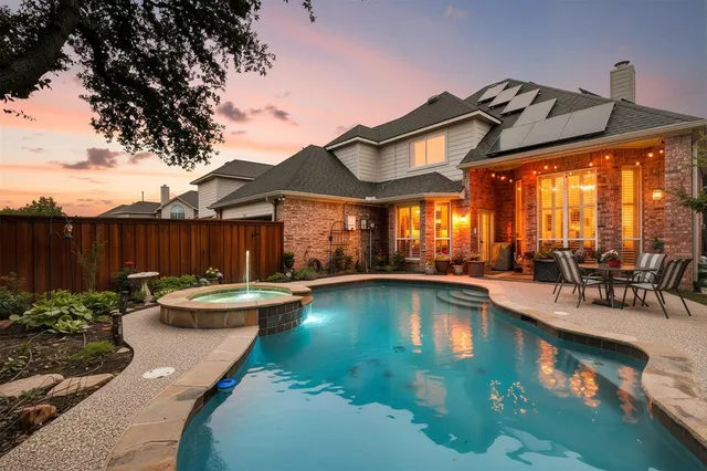 a view of a swimming pool with a table and chairs under an umbrella
