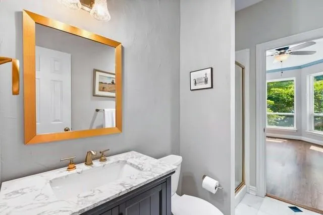 a bathroom with a granite countertop sink mirror and a toilet