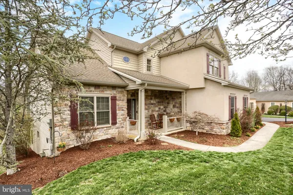 a front view of a house with a yard outdoor seating and garage