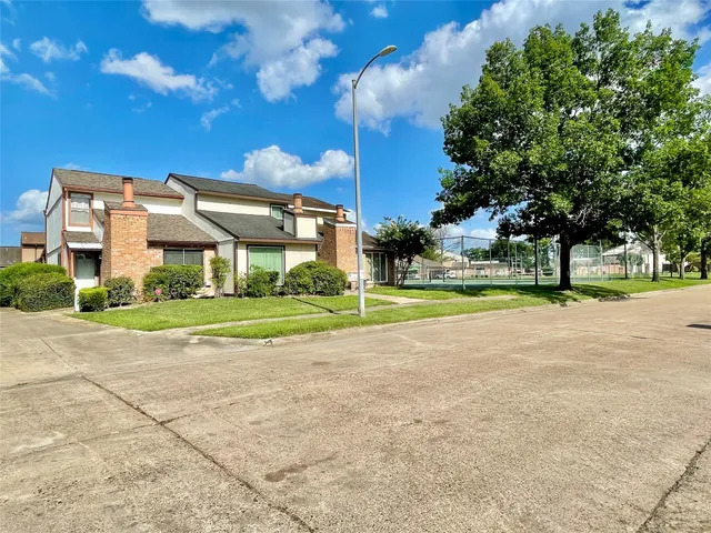 a front view of a house with a big yard and a fountain