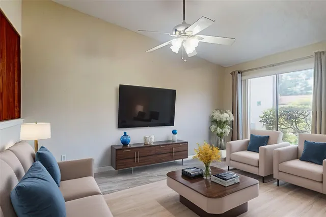a living room with furniture a flat screen tv and a large window