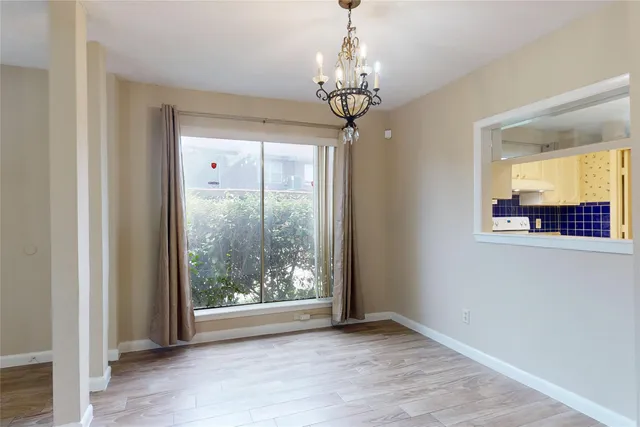a view of a livingroom with a chandelier curtains and wooden floor