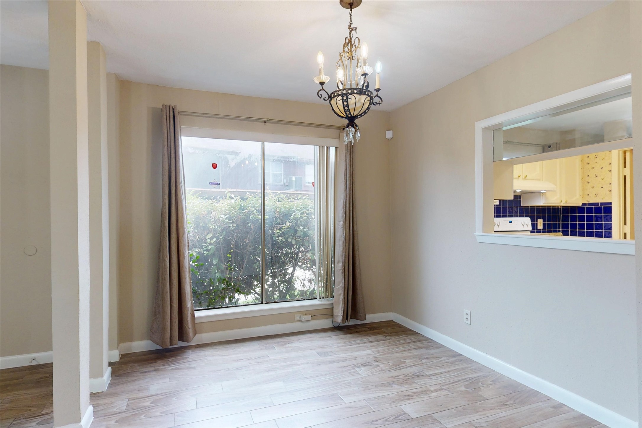 7840 Bateman Lane Houston, TX 77088 - Photo 10 of 25 a view of a livingroom with a chandelier curtains and wooden floor