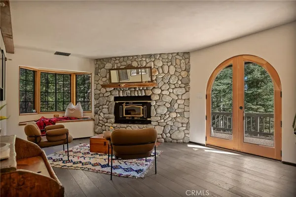 a living room with furniture a fireplace and a floor to ceiling window