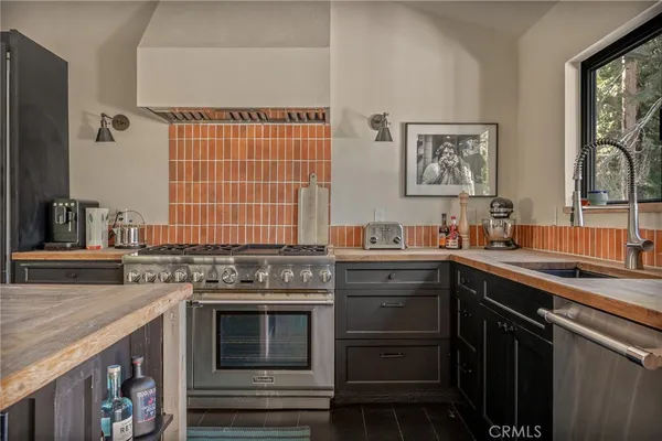 a kitchen with stainless steel appliances granite countertop a sink stove and cabinets