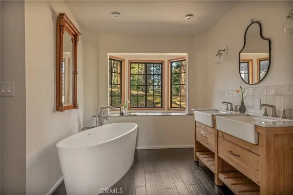 a bathroom with a tub sink and mirror