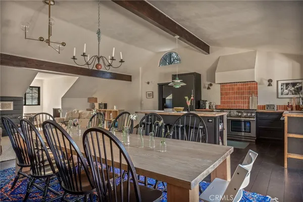 a view of a dining room and kitchen with furniture wooden floor and chandelier