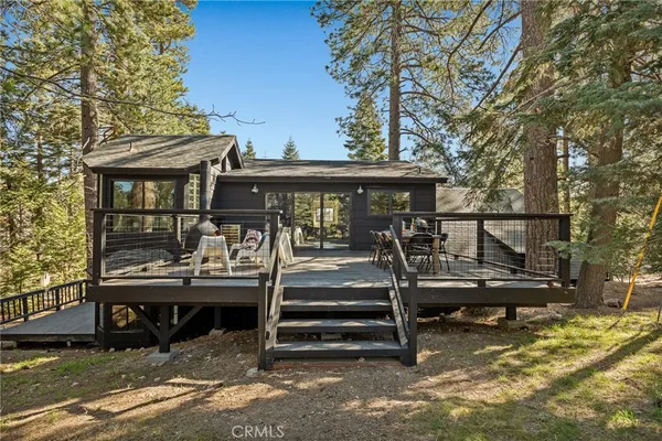 a view of backyard with deck and outdoor seating