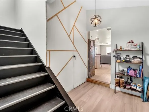 a kitchen with refrigerator a microwave a stove and furniture with wooden floor