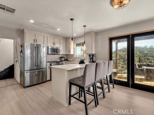 14091 Highview Trail Redding, CA 96003 - Photo 8 of 61 a kitchen with refrigerator a microwave a stove and furniture with wooden floor