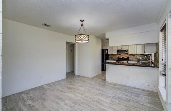 a view of a kitchen with a sink cabinet and refrigerator