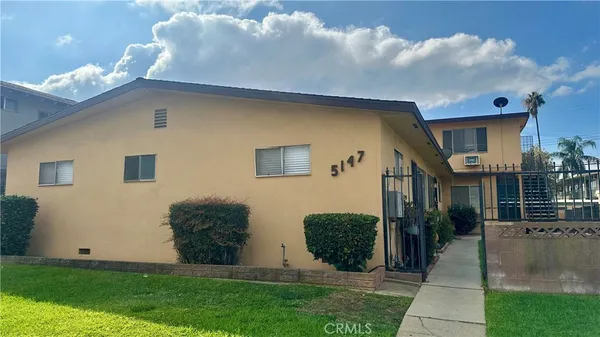 a view of a house with many windows and a yard