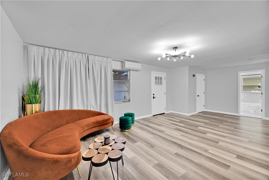a view of a livingroom and a dining room with furniture wooden floor and a chandelier
