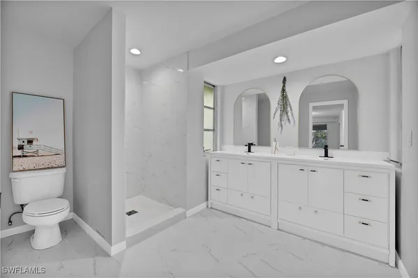 a spacious bathroom with a double vanity sink mirror and toilet