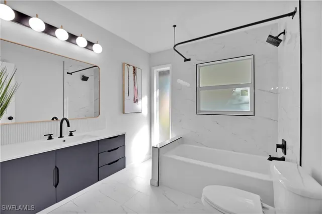 a bathroom with a tub toilet sink and mirror