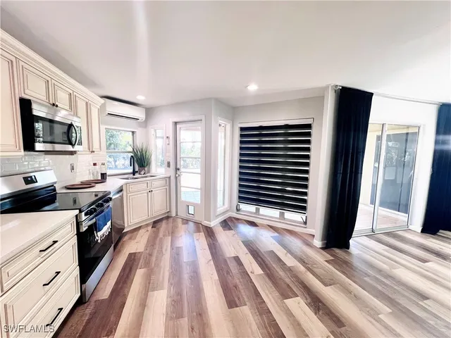 a kitchen with stainless steel appliances a stove top oven a refrigerator and a sink