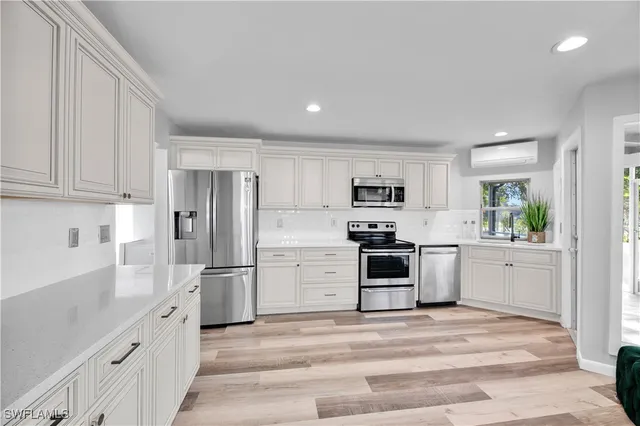 a kitchen with white cabinets and stainless steel appliances