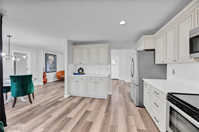 a large white kitchen with cabinets