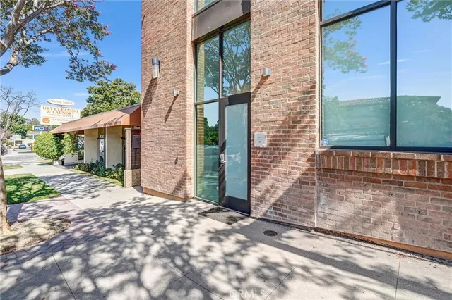 a view of a brick house with a large tree