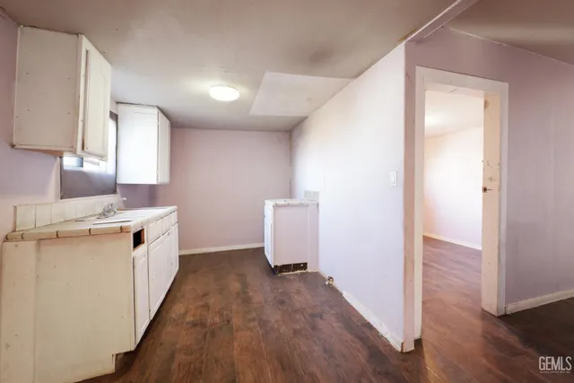 a kitchen with a sink a refrigerator and wooden floor