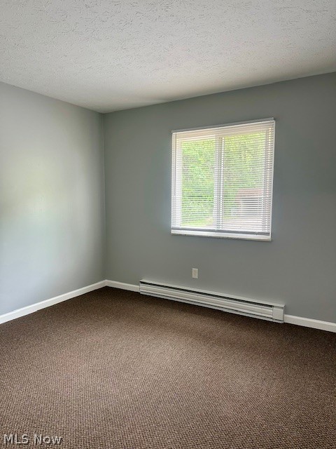 4376 Darrow Road, Unit 2 Stow, OH 44224 - Photo 14 of 26 Empty room with a baseboard heating unit, dark colored carpet, baseboards, and a textured ceiling