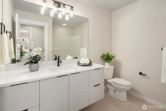 a bathroom with a toilet a sink and a mirror