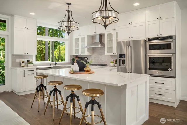 a kitchen with stainless steel appliances a table chairs refrigerator and microwave