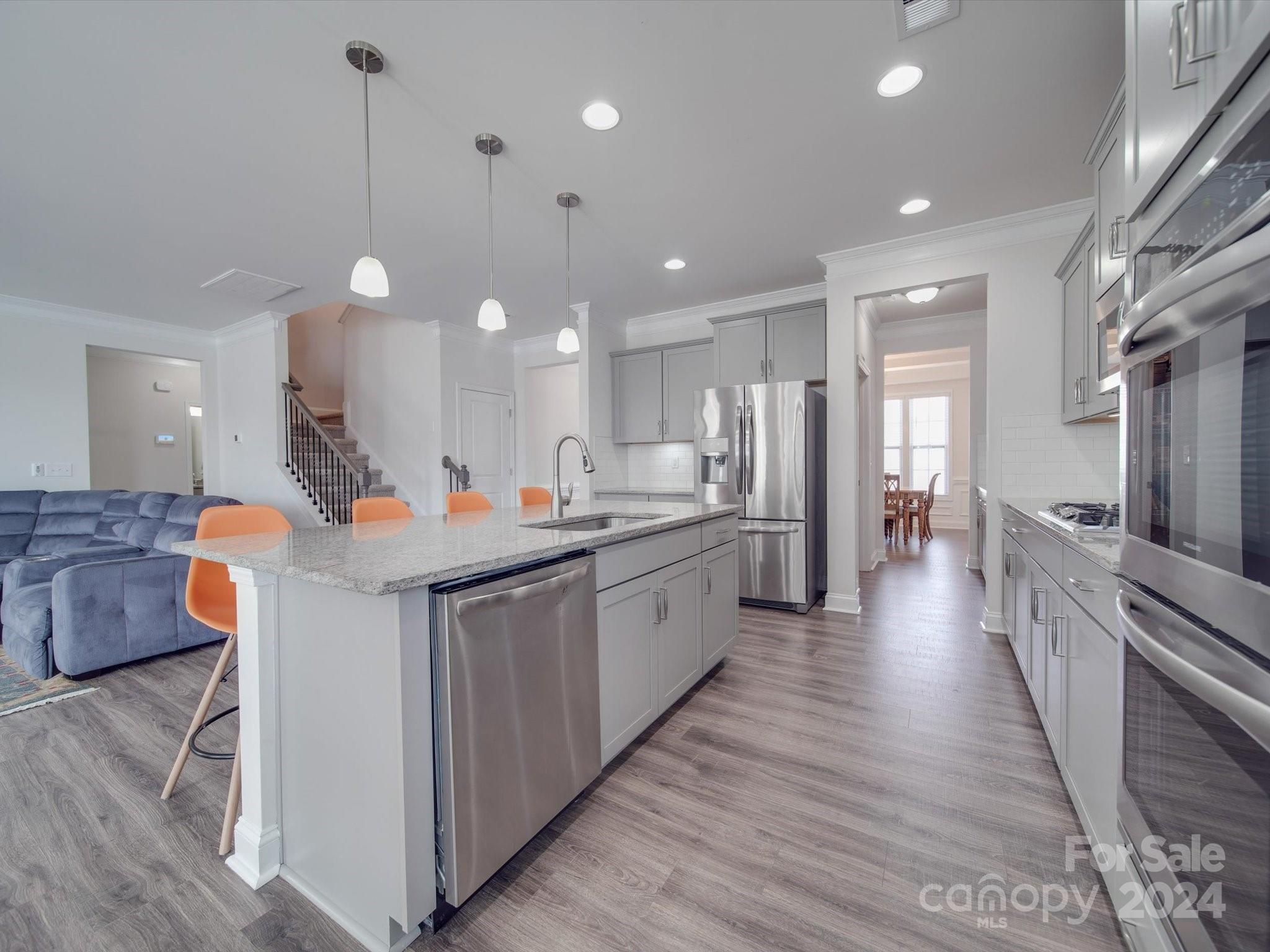 5901 Redwood Pine Road Concord, NC 28027 - Photo 14 of 39 a large kitchen with stainless steel appliances kitchen island a large counter top a sink a window and a living room view