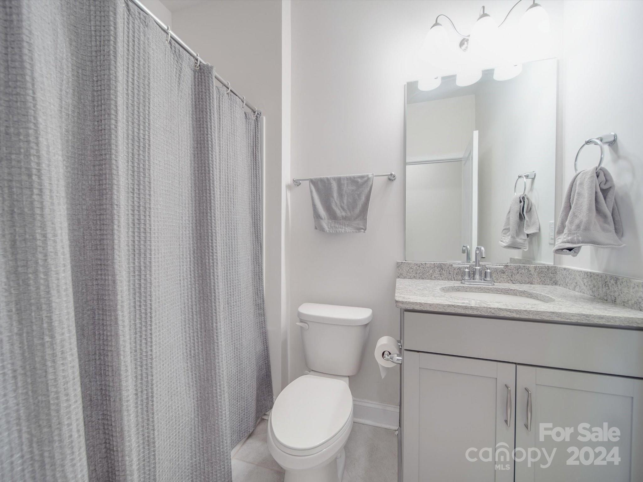 5901 Redwood Pine Road Concord, NC 28027 - Photo 21 of 39 a bathroom with a granite countertop sink toilet and mirror