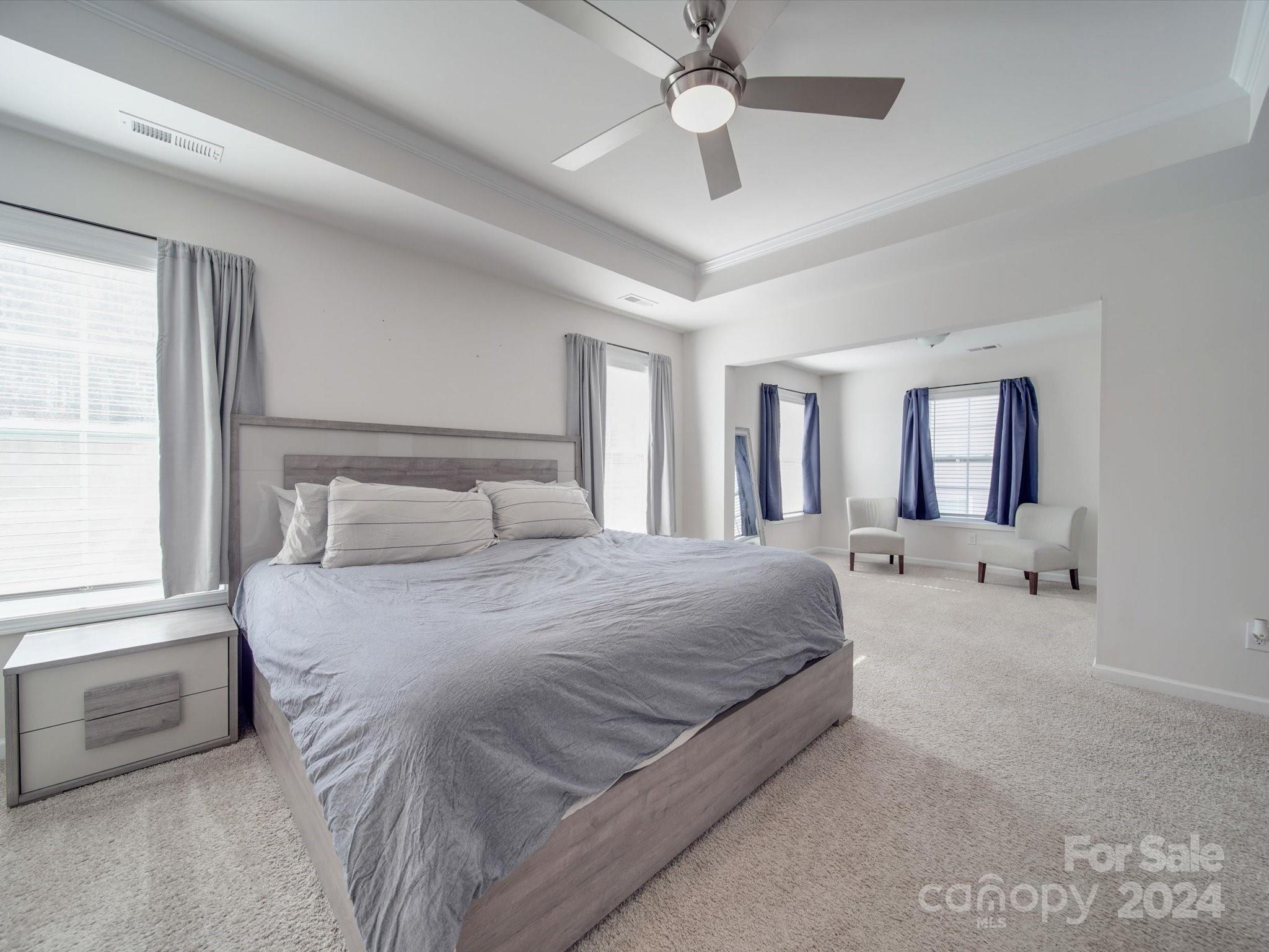 5901 Redwood Pine Road Concord, NC 28027 - Photo 27 of 39 a bedroom with a large bed a chandelier and windows