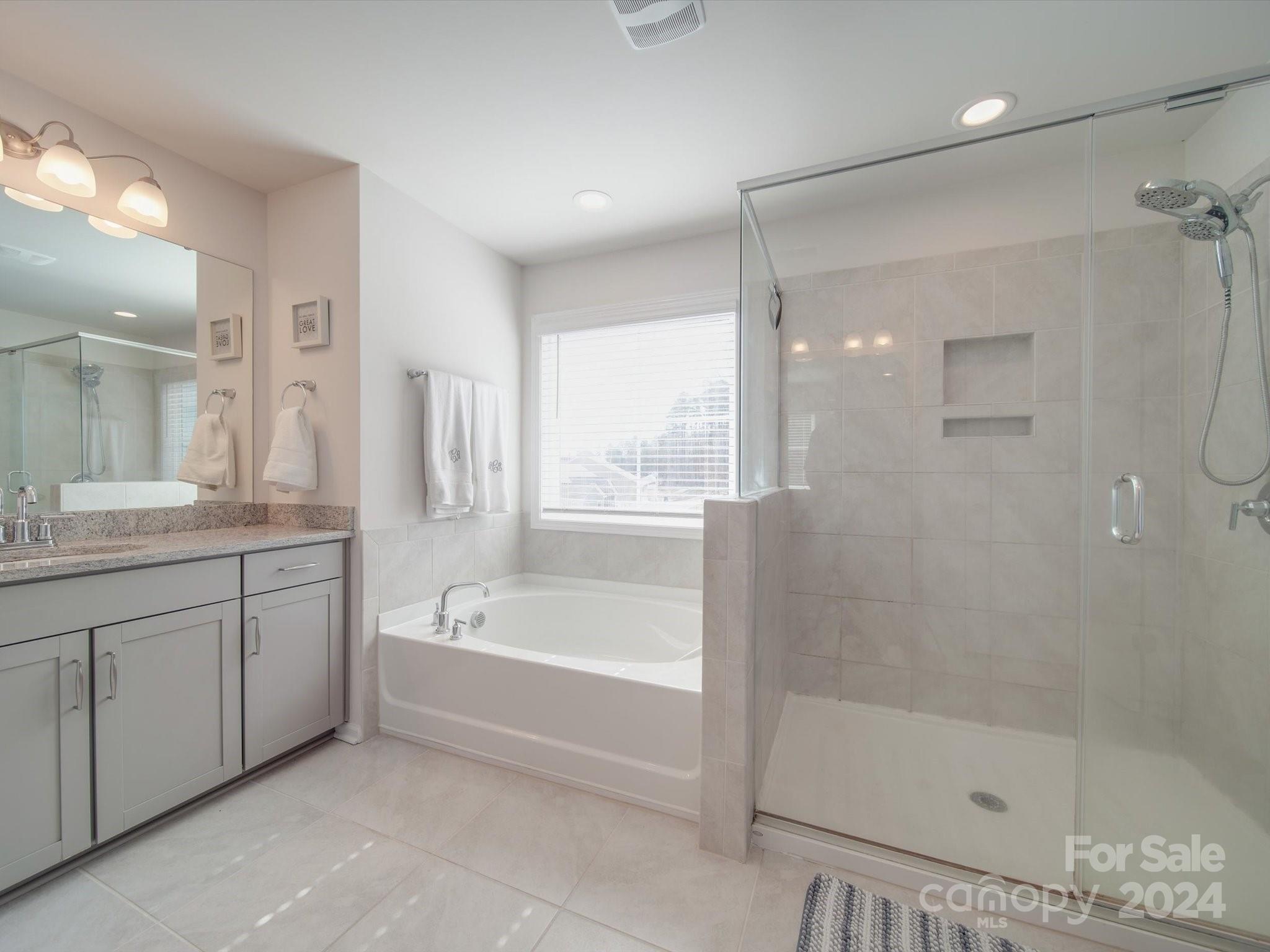 5901 Redwood Pine Road Concord, NC 28027 - Photo 30 of 39 a bathroom with a bathtub shower sink vanity and mirror