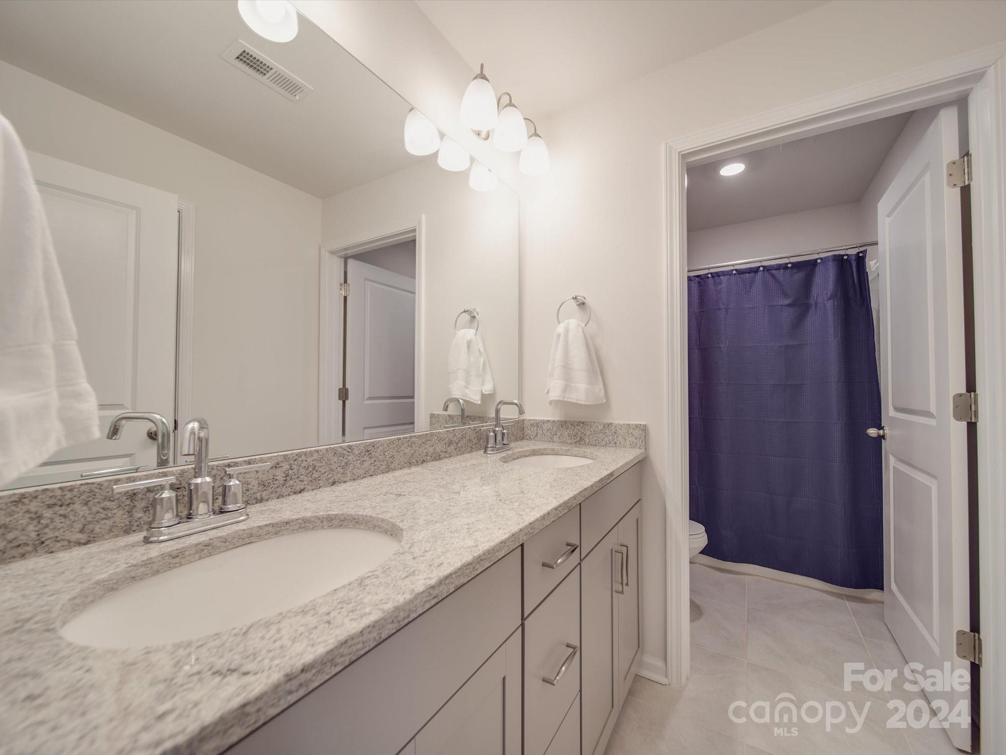 5901 Redwood Pine Road Concord, NC 28027 - Photo 38 of 39 a bathroom with a granite countertop double vanity sink and a mirror