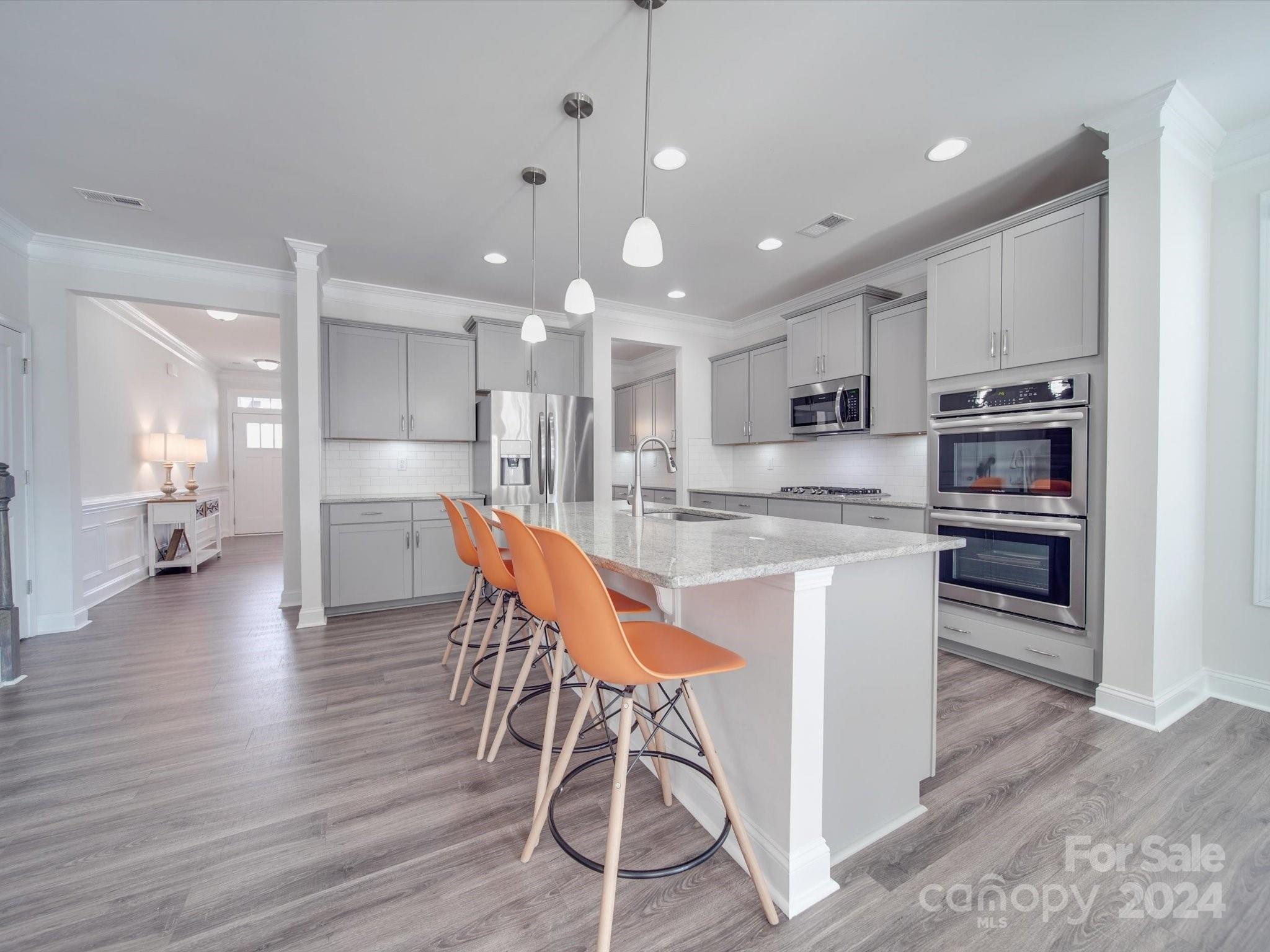 5901 Redwood Pine Road Concord, NC 28027 - Photo 10 of 39 a kitchen with stainless steel appliances kitchen island granite countertop white cabinets and wooden floor