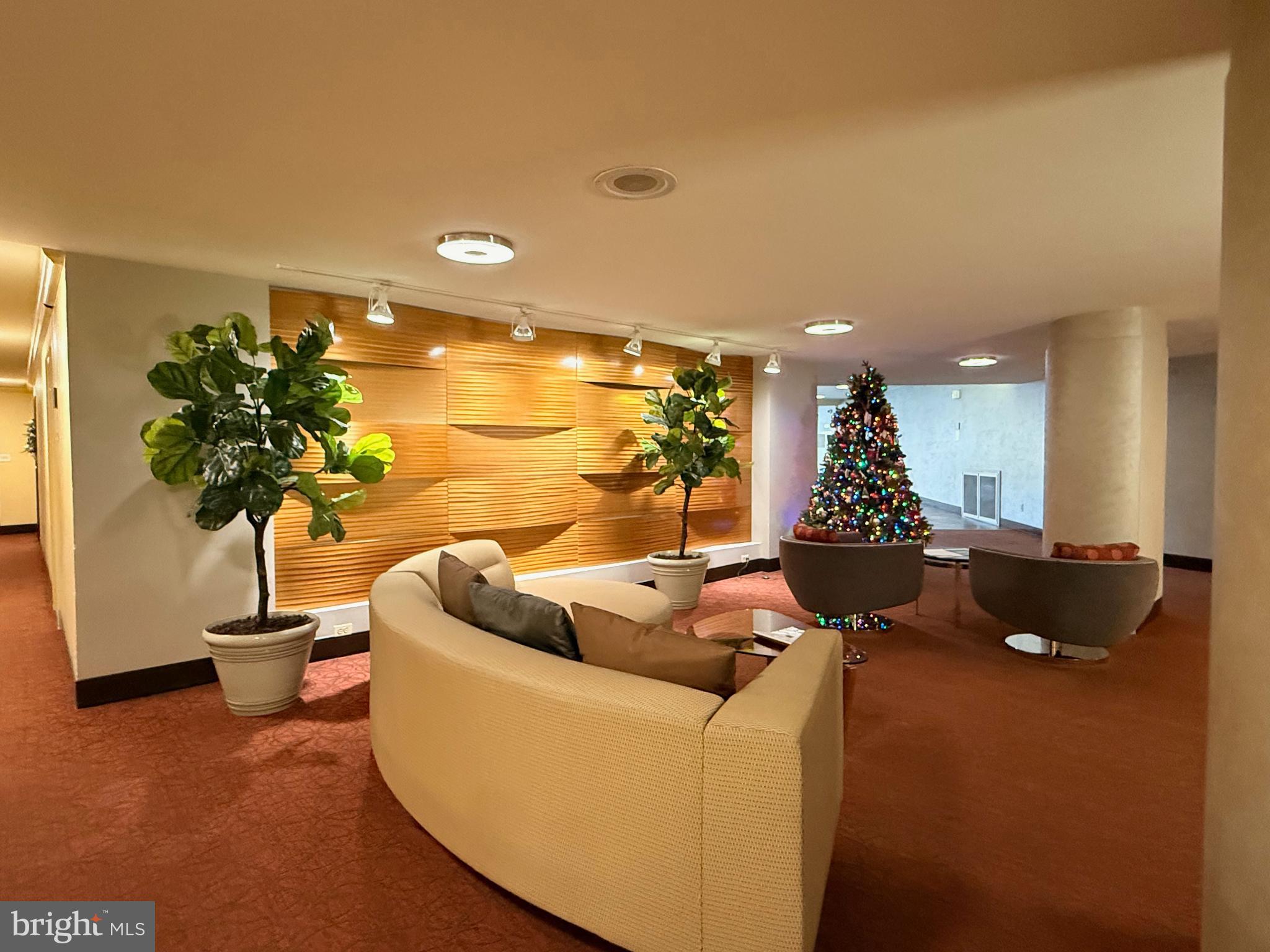 4740 Connecticut Avenue Northwest, Unit 112 Washington, DC 20008 - Photo 19 of 20 Festive lobby with modern decor and greenery.