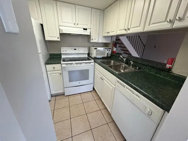 a kitchen with a sink cabinets and appliances