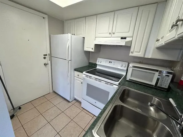 a view of a refrigerator and cabinets